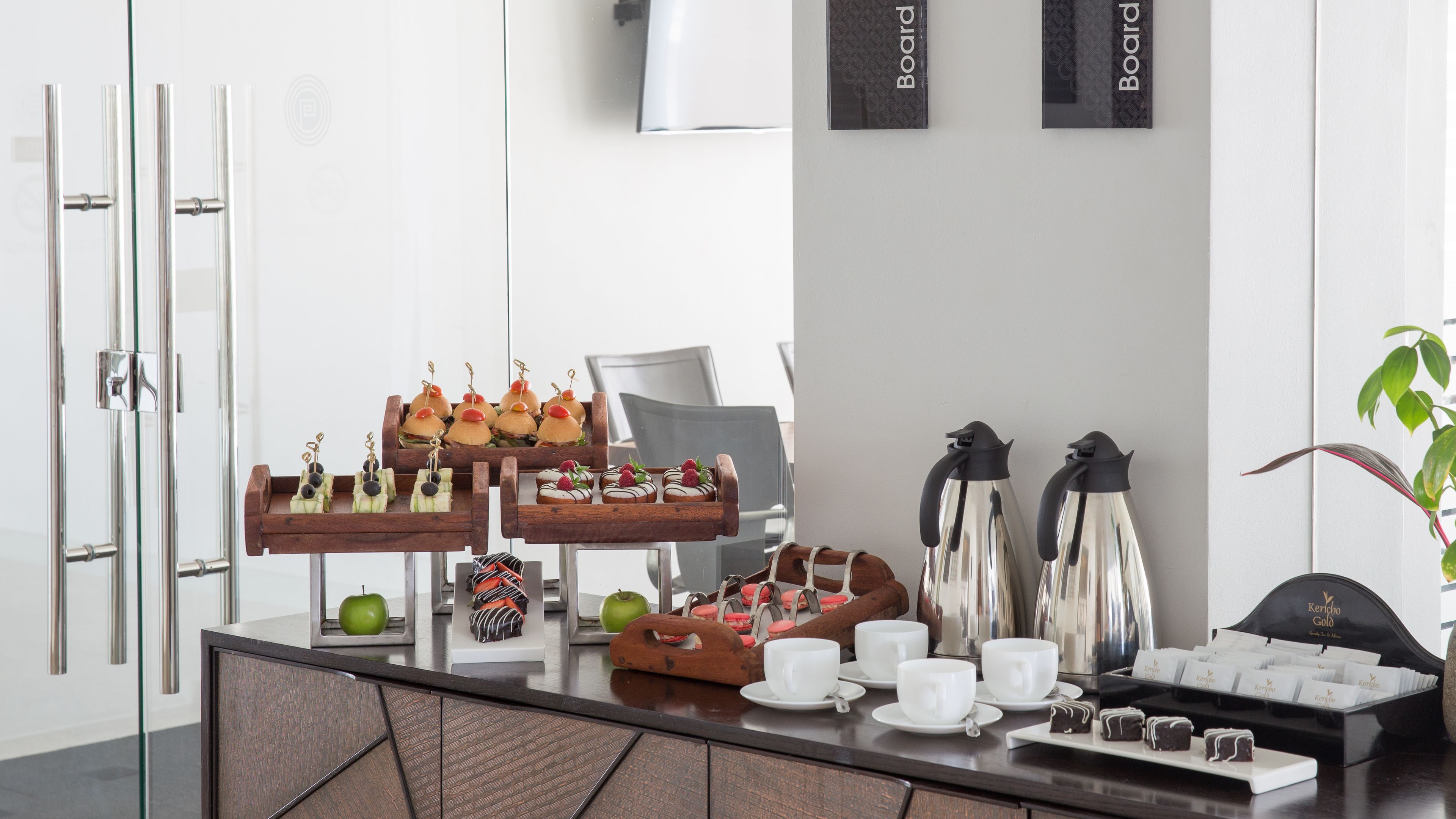 A buffet setup with various food items and a coffee station.
