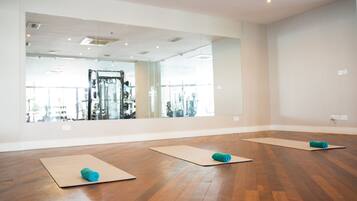 A spacious room with wooden flooring and large mirrors.