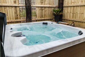 A hot tub with a wooden deck and a wooden fence in the background. - Somerset Country Escape (Taunton)