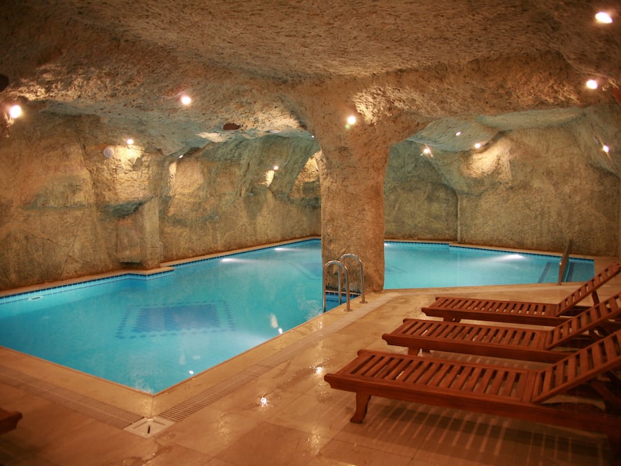 Una piscina cubierta, tumbonas