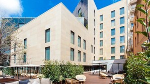A modern building with a courtyard featuring outdoor seating and a glass facade. - Eurostars Barcelona Central (Barcelona)