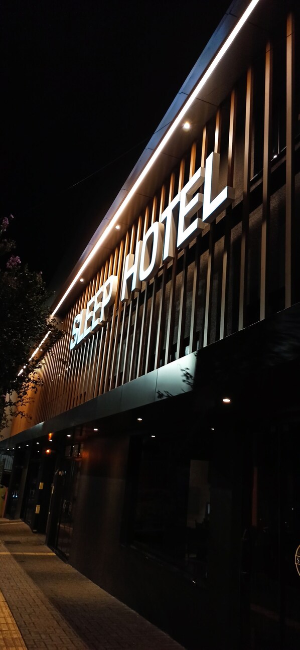 A building with a sign that reads "SLEEP HOTEL" illuminated at night. - Sleep Hotel (Toledo)