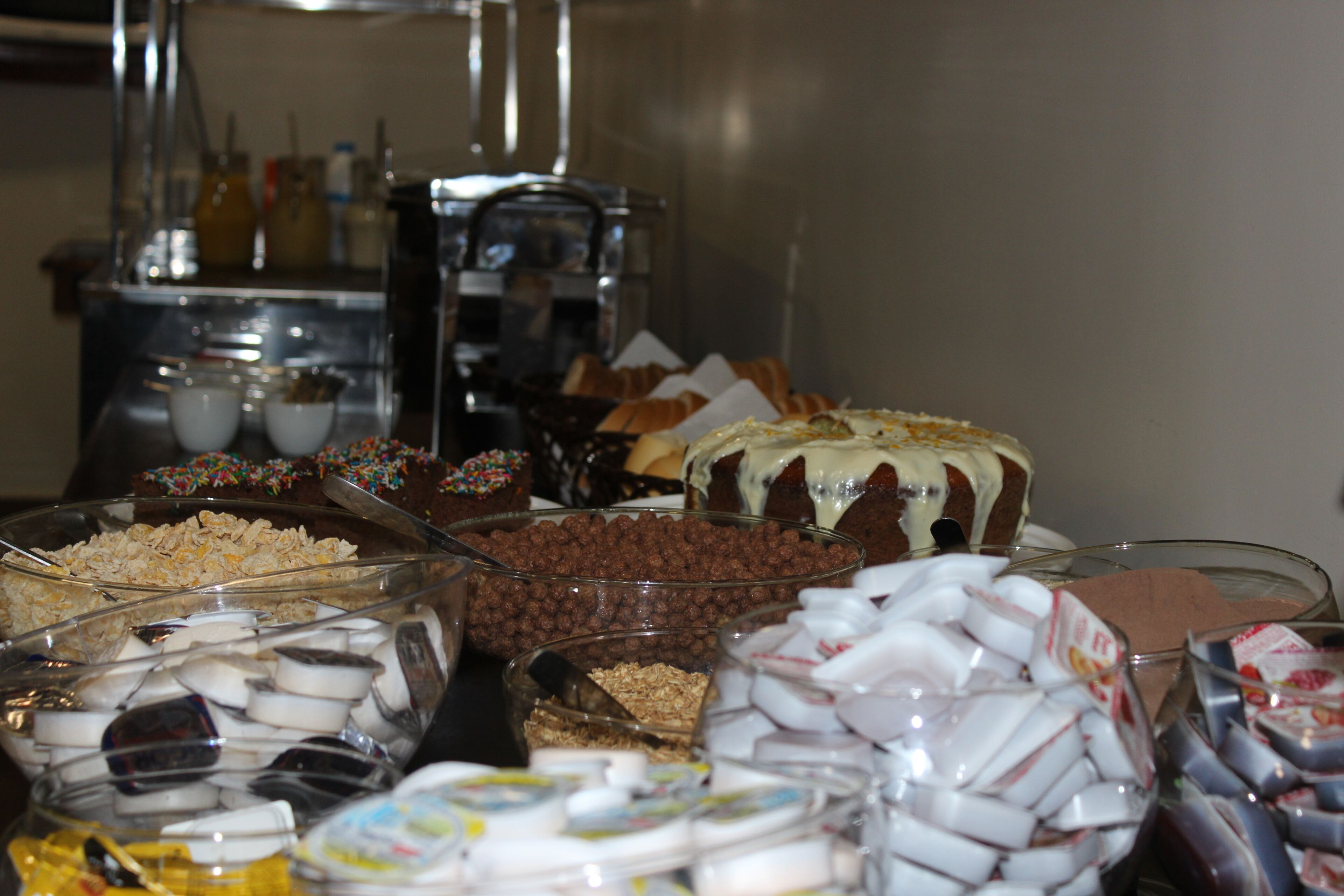 A buffet with various food items including cereal, chocolate, and desserts.