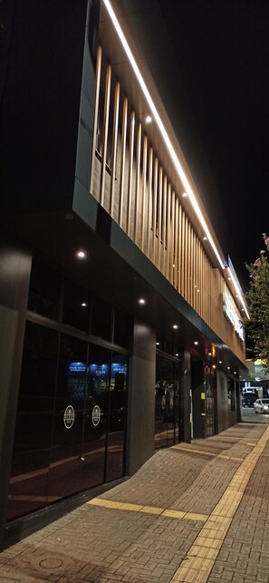 A modern building with a flat roof, large glass windows, and a wooden facade. - Sleep Hotel (Toledo)
