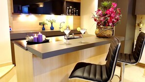A modern kitchen with a central island, bar stools, and a decorative vase with flowers. - Villa Carlos (Patras)