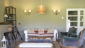 Un salon avec un canapé, un banc, un vélo et deux chaises.