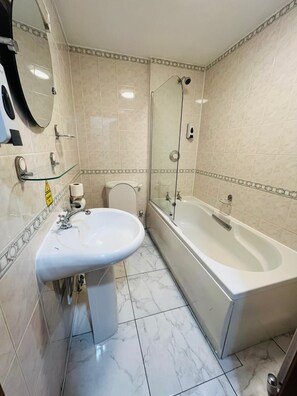 A bathroom with a sink, toilet, and bathtub.