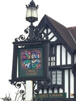 Placa de pub com vitral e o nome 'GEORGE & DRAGON'.