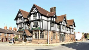 Un edificio de estilo Tudor tradicional con un letrero del pub 'George & Dragon'.
