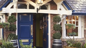 A traditional house with a dark blue door, white-framed windows, and a tiled roof.