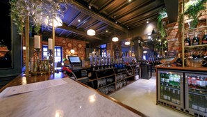 A bar area with a marble countertop, a cash register, and a wine cooler.