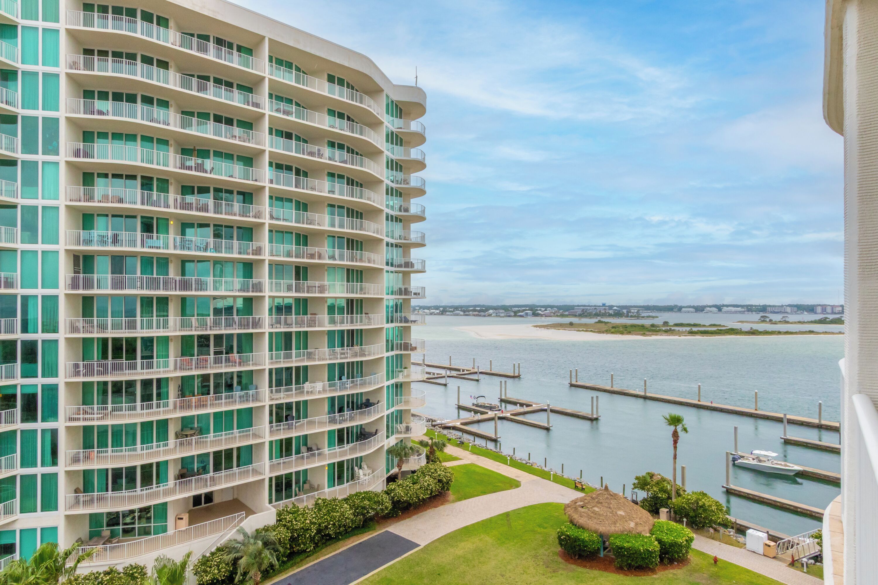 A multi-story hotel with balconies, a marina, and a view of the water.