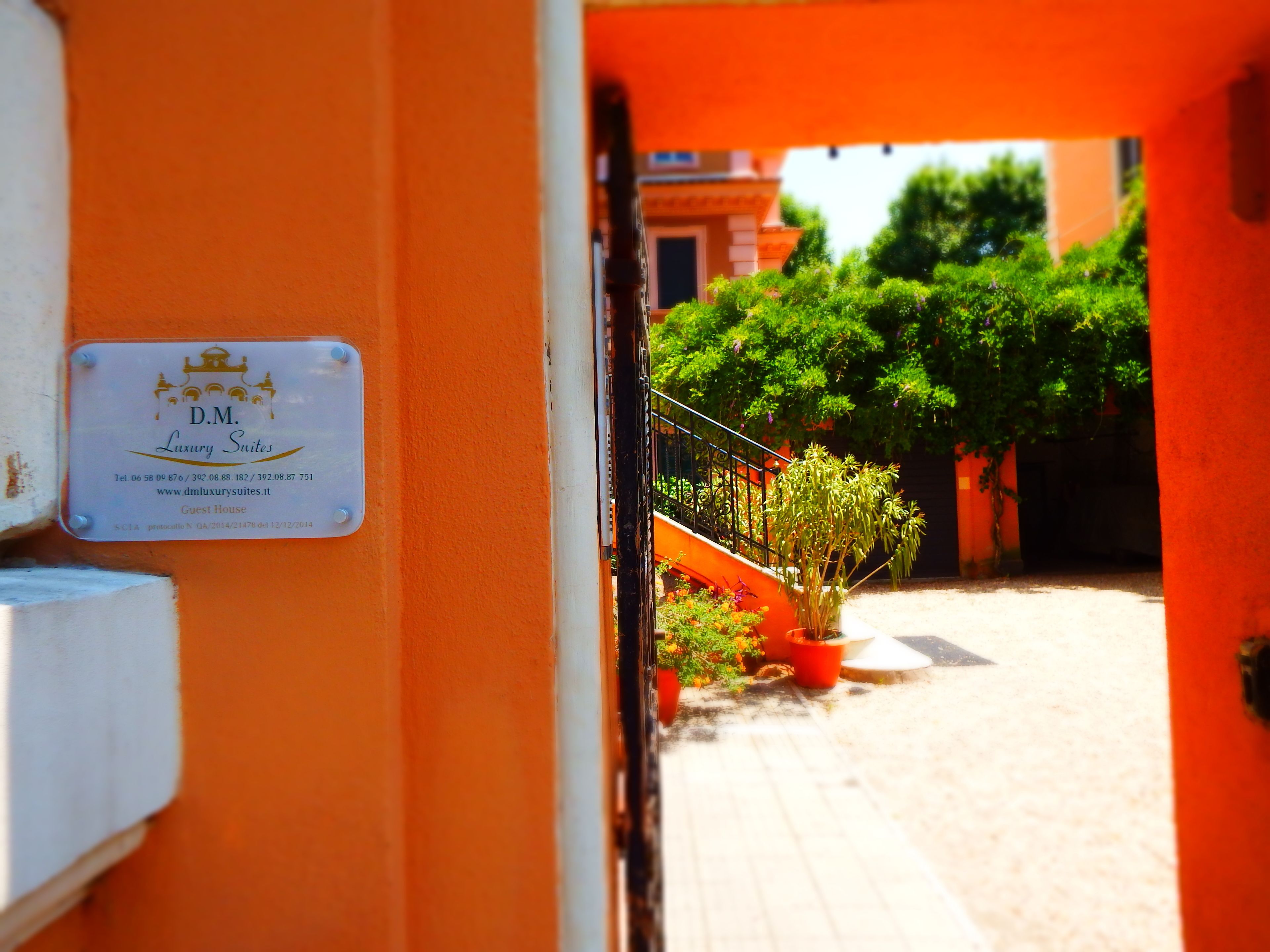 A sign for D.M. Luxury Suites with contact information and a website URL.