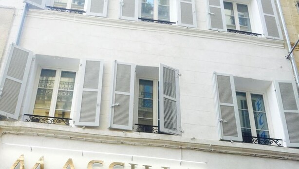Het uiterlijk van Hotel Massilia, met een opvallend bord, grote ramen en een balkon.
