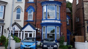 A row of terraced houses with a blue car parked in front. - The Chimes (Bridlington)