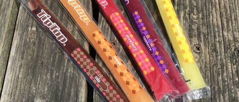 Five packaged items with distinct patterns and text on a wooden surface.