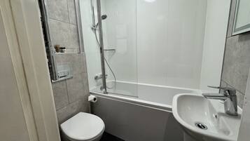 A bathroom with a toilet, a sink, and a shower.