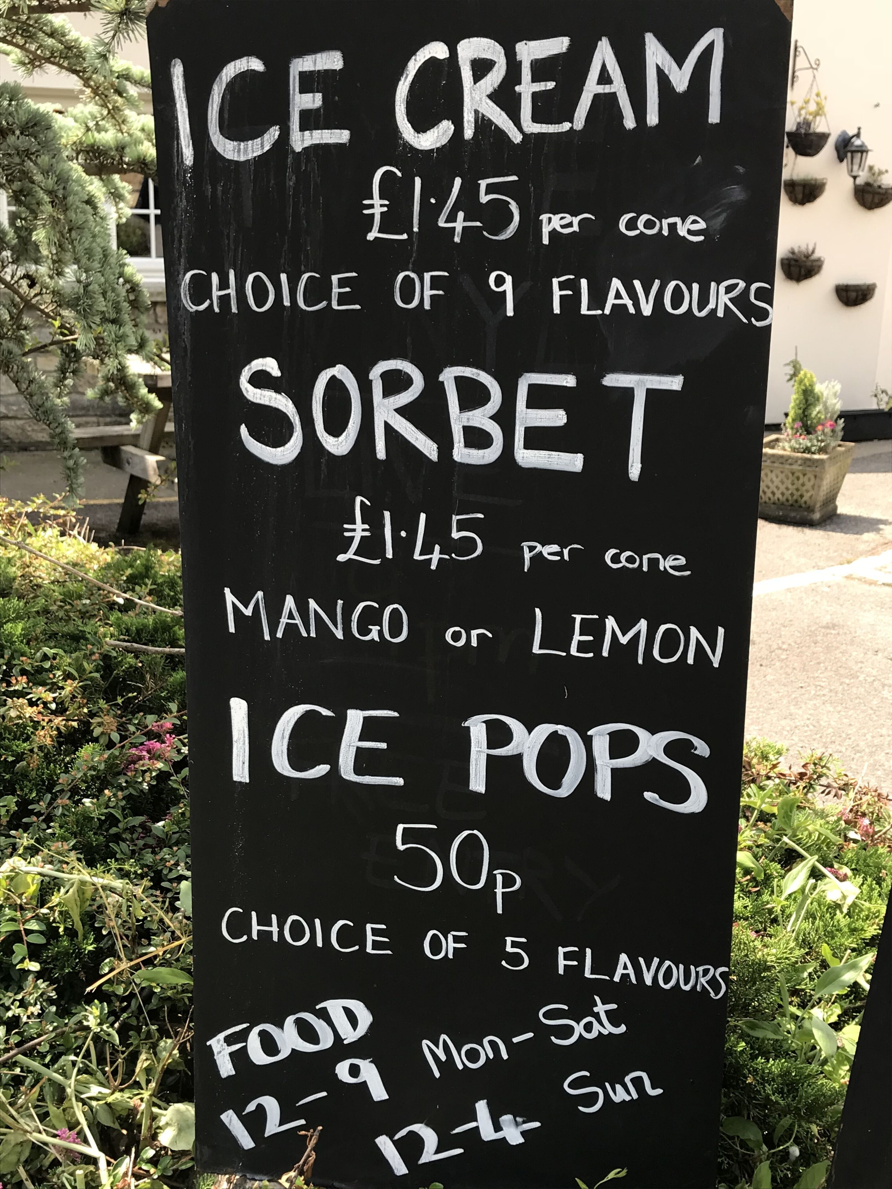 A blackboard menu listing ice cream, sorbet, and ice pops with prices and flavor choices.