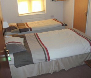 A room with two beds, a window, and a door. - Heritage Hotel (Leicester)