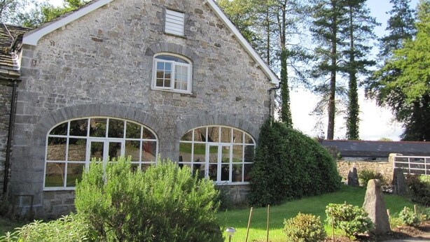A stone building with two arched windows and a small dormer window. - Glynhir Mansion (Ammanford)