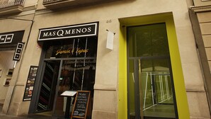 A building with multiple balconies and a storefront with a sign reading "MAS Q MENOS". - Cosmo Apartments Rambla de Catalunya (Barcelona)