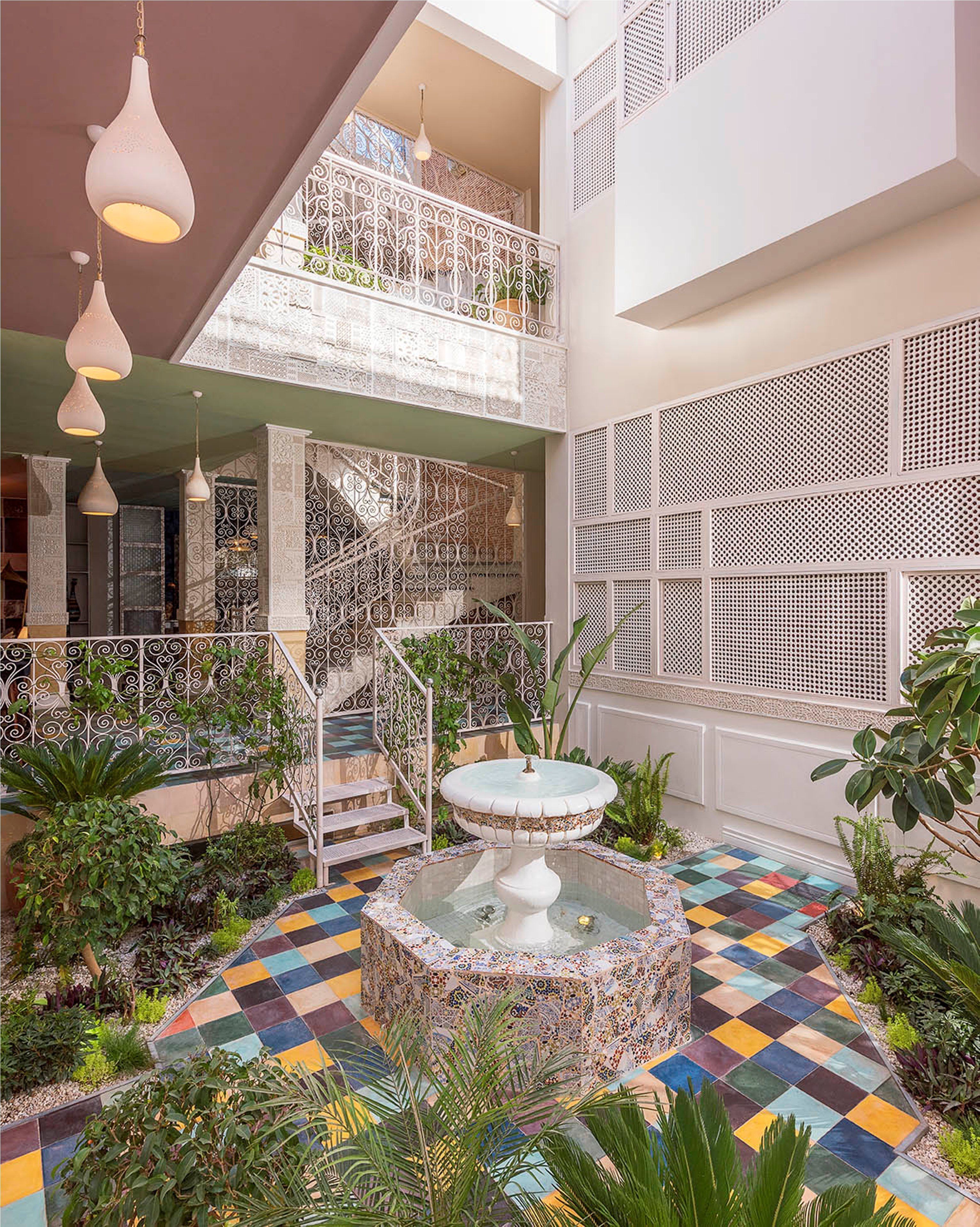 A multi-level atrium with a central fountain, decorative railings, and a checkered floor.