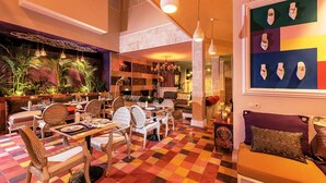 Un restaurante con suelo a cuadros, muebles de mimbre e iluminación colgante.