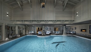 Una piscina techada, sillones reclinables de piscina