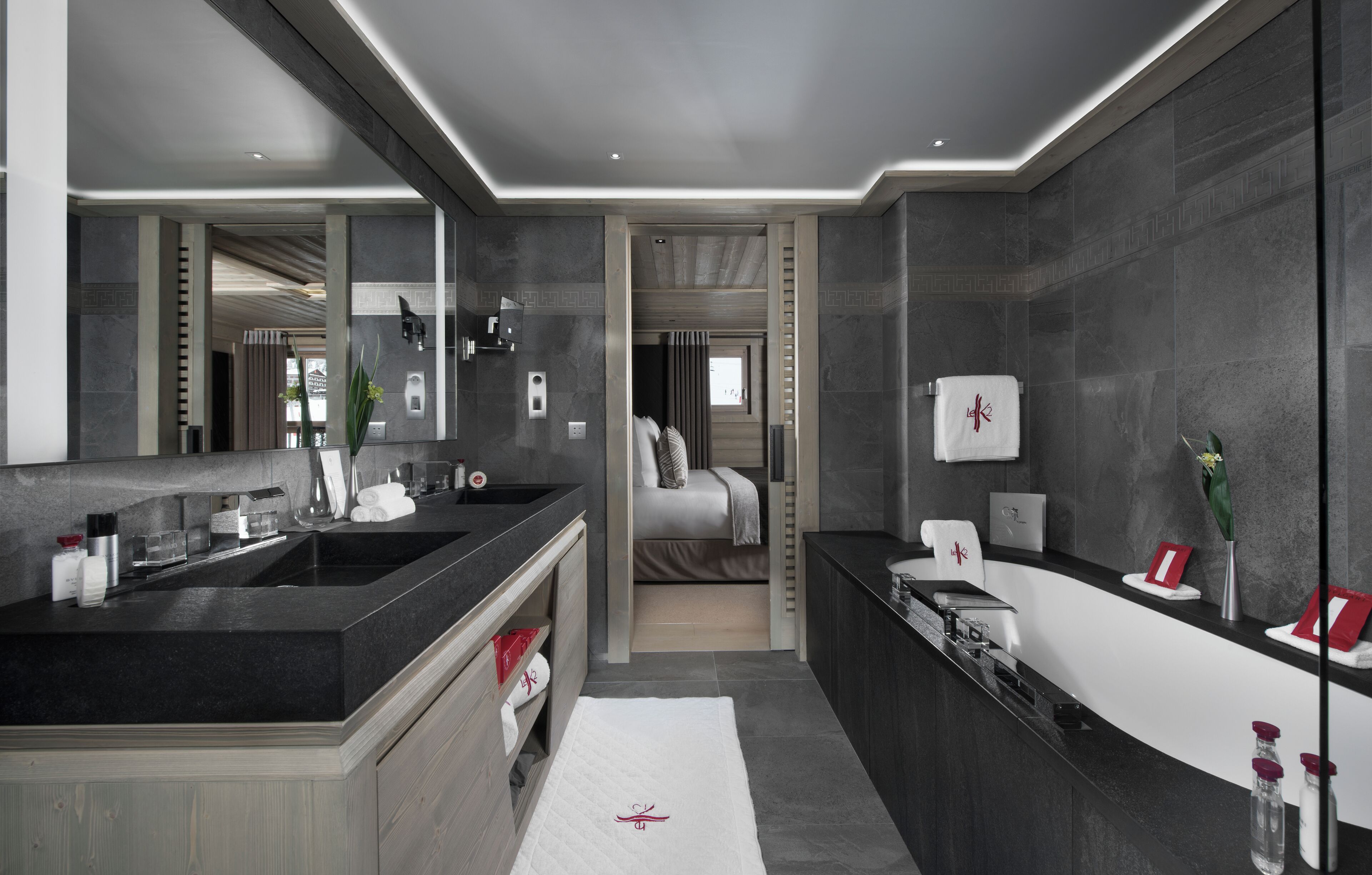 A modern bathroom with a large mirror, dual sinks, and a vanity.