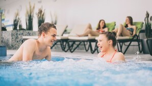 A pool area with lounge chairs and a hot tub. - Wellnesshaus Waldmunchen (Waldmuenchen)