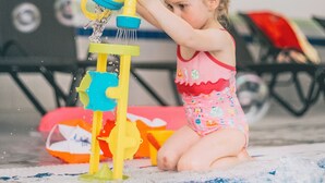 A child playing with a water play structure in a pool area. - Wellnesshaus Waldmunchen (Waldmuenchen)