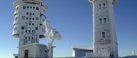 Dos edificios blancos cubiertos de nieve, con numerosas ventanas y una cúpula.