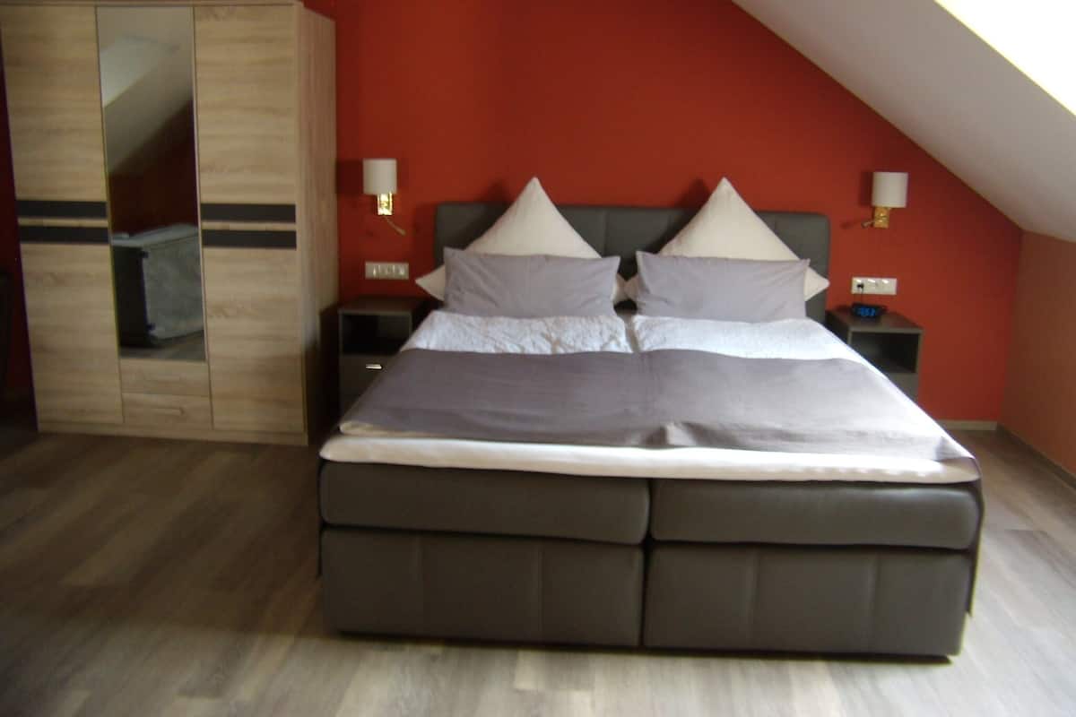 Un dormitorio con cama, mesitas de noche y armario.
