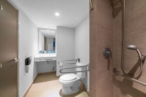 Un baño moderno con inodoro, lavamanos y ducha.