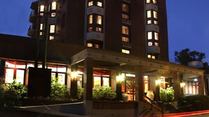 Ein mehrstöckiges Hotel mit beleuchteten Fenstern und einem gut ausgeleuchteten Eingang.