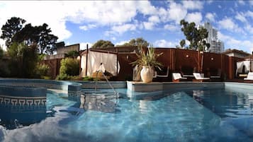 Una piscina al aire libre, sombrillas