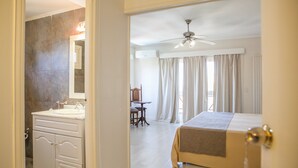 Ein Hotelzimmer mit Bett, Bad mit Waschbecken und Spiegel sowie Schreibtisch und Stuhl.