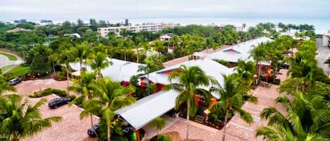 A resort with multiple buildings, palm trees, and a view of the ocean.