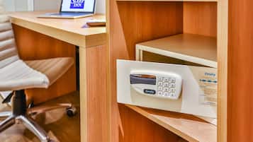 Un escritorio de madera con una laptop mostrando el logotipo de Sleep Inn, un panel de control blanco de Onity y una silla de oficina blanca.