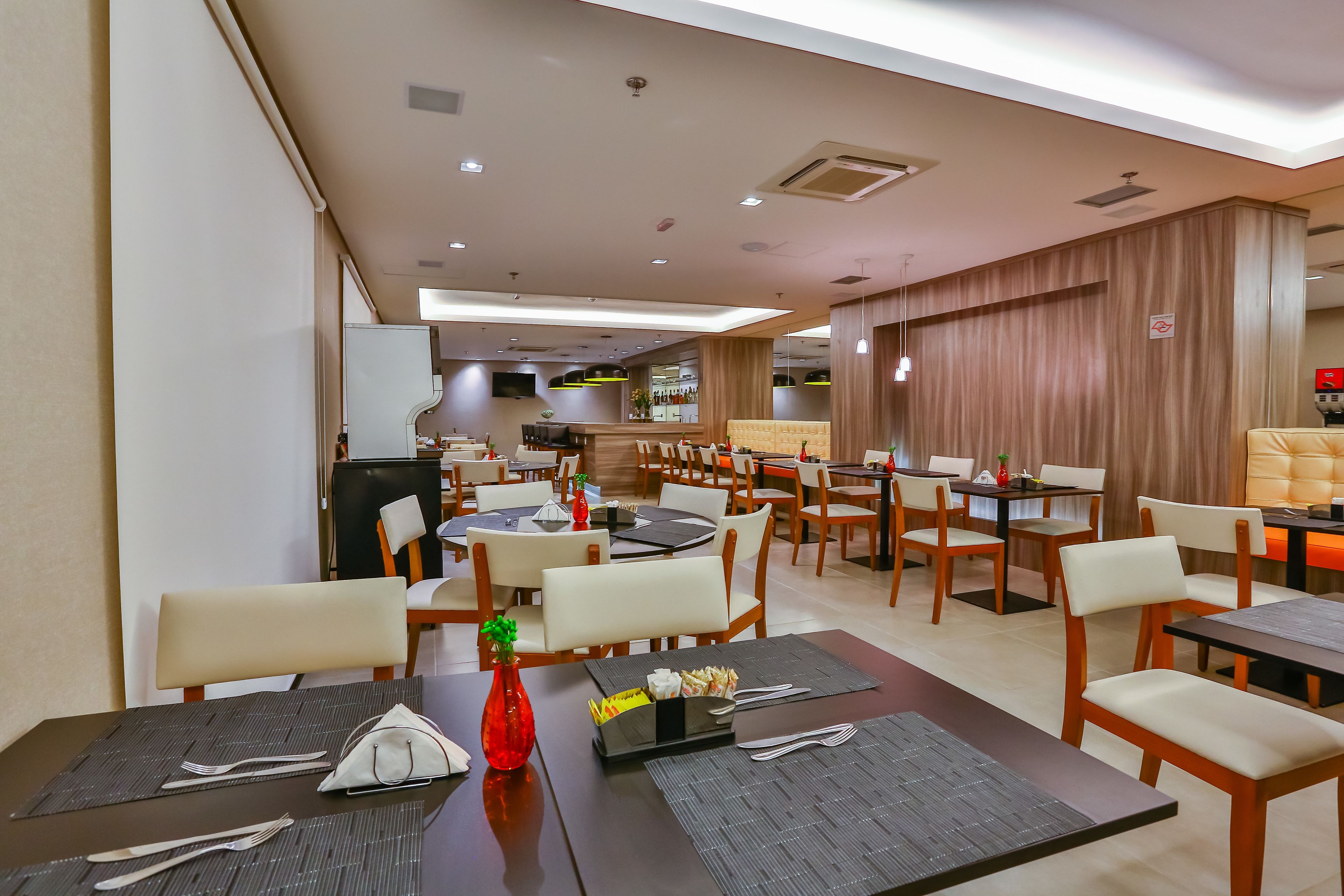A restaurant with multiple tables, chairs, and a bar area.