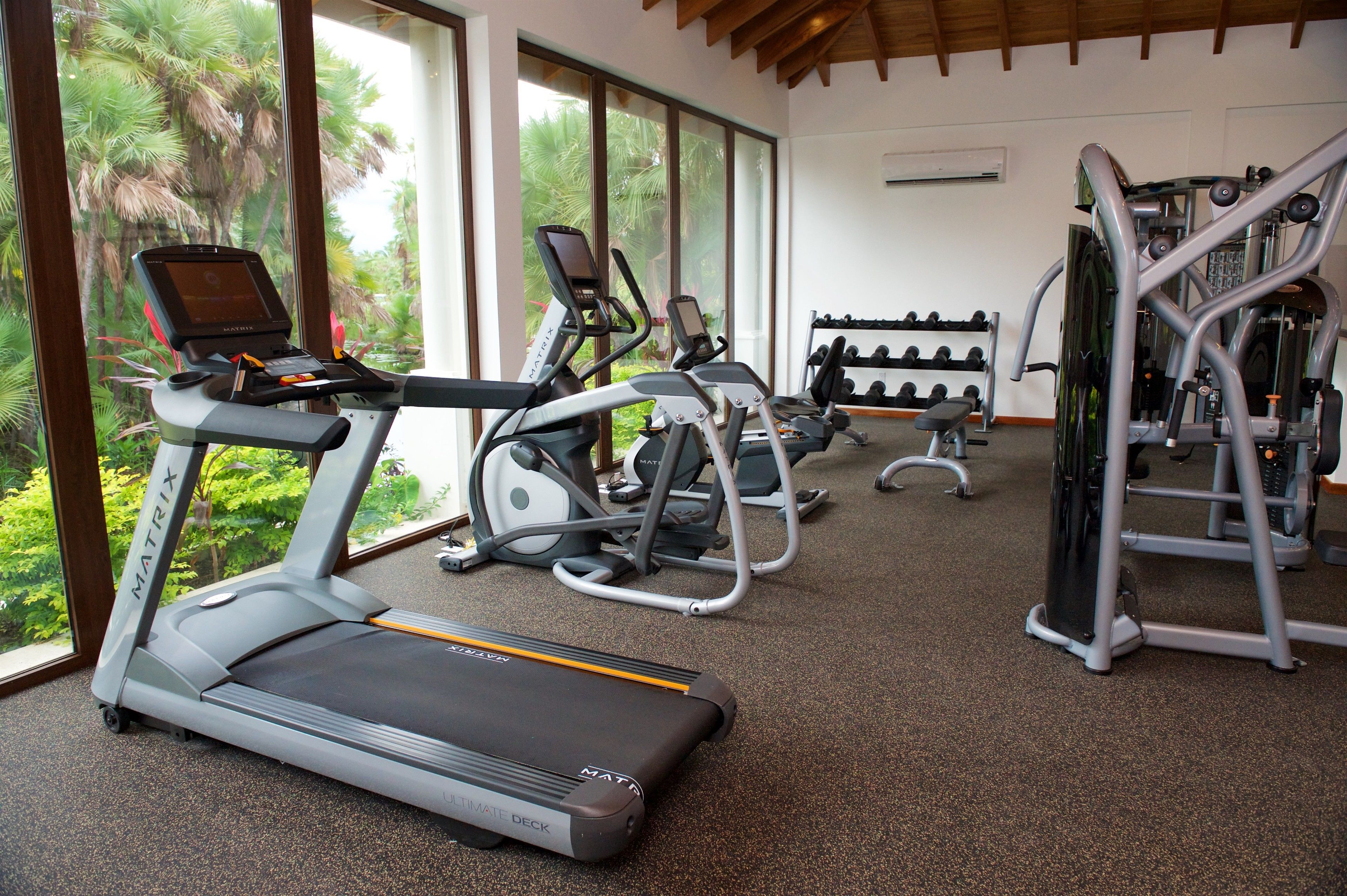 Ein Fitnessstudio mit Laufbändern, Crosstrainern und Kraftgeräten.