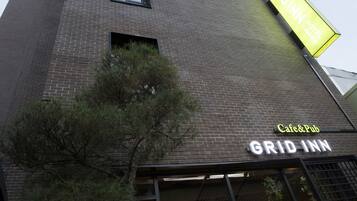 A tall brick building with a sign for 'GRID INN HOTEL & CAFE & PUB'.