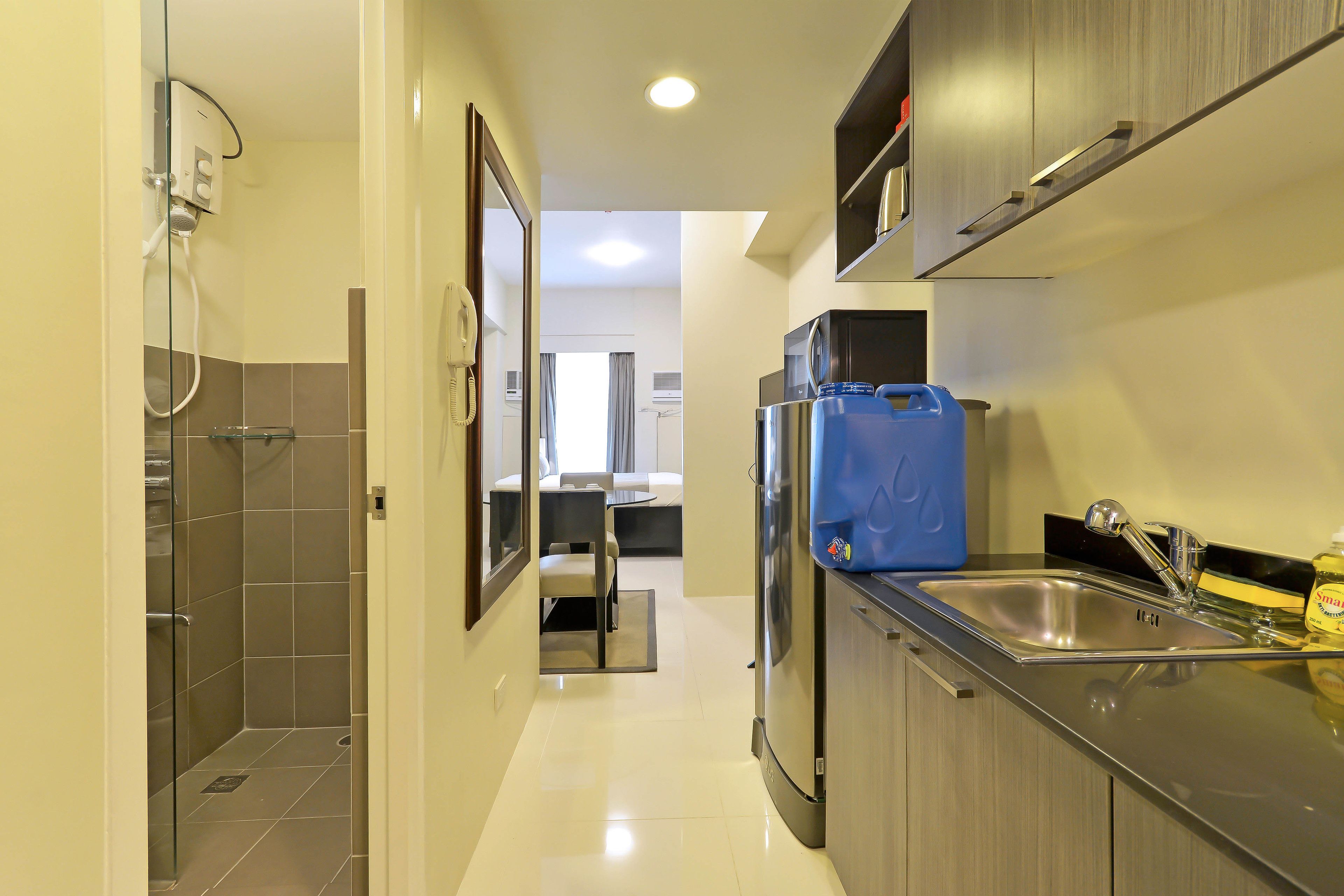 Una cocina moderna con un refrigerador de acero inoxidable, un lavamanos y un dispensador de agua azul.