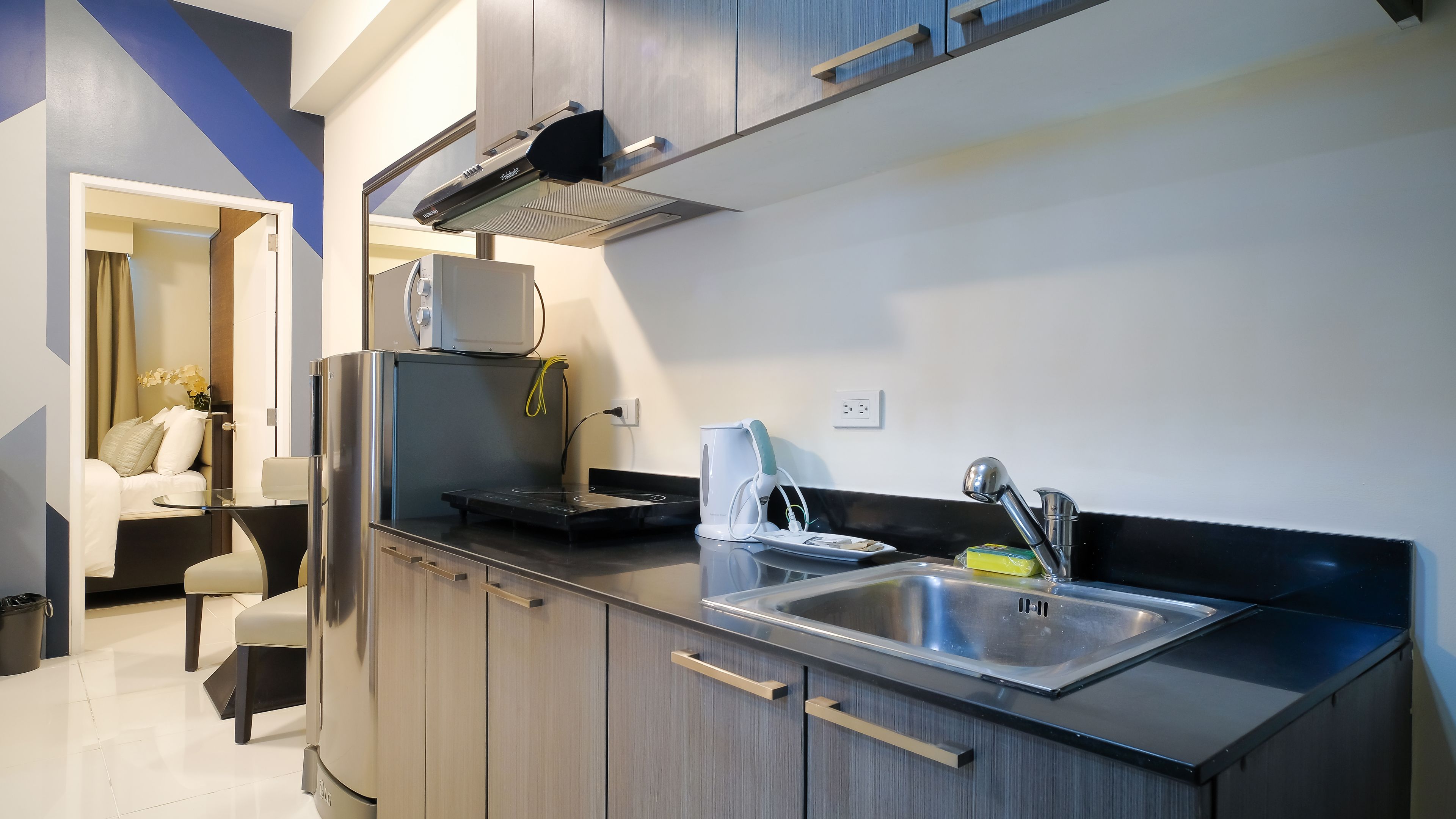 A modern kitchen with stainless steel appliances, a built-in oven, and a sink.