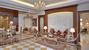 Un interior lujoso con muebles ornamentados, un candelabro y un papel tapiz con diseño.