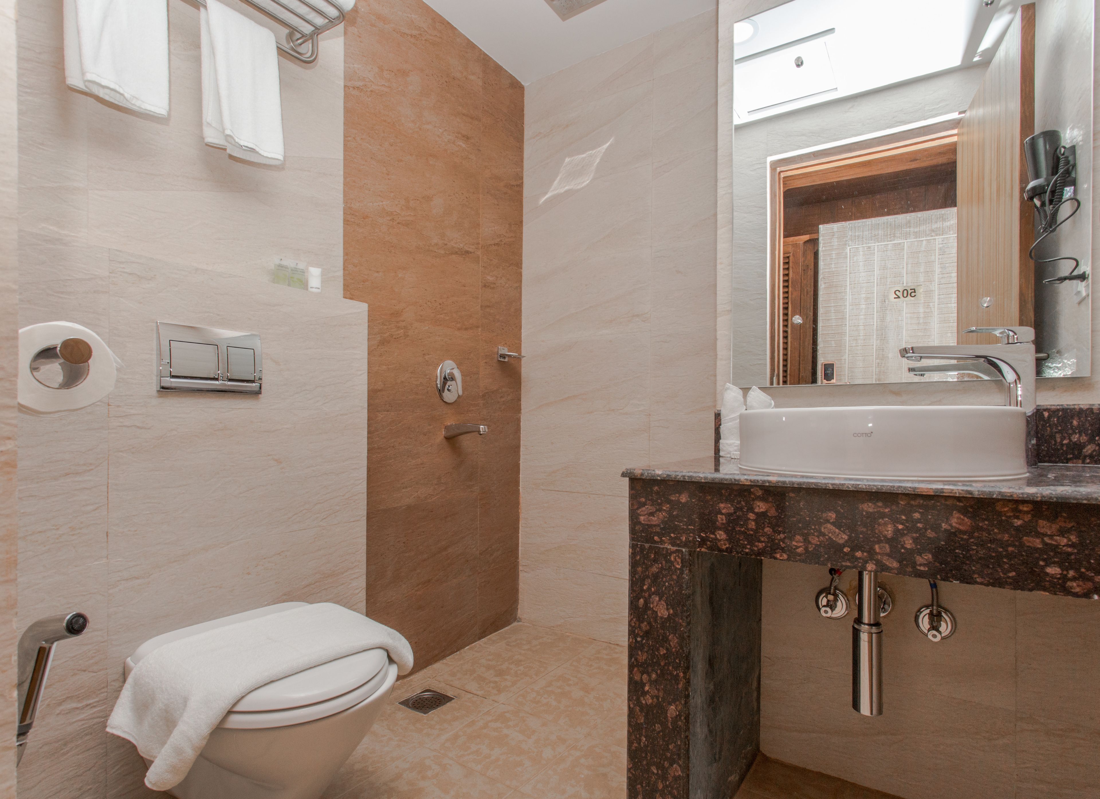 A bathroom with a toilet, sink, and shower.