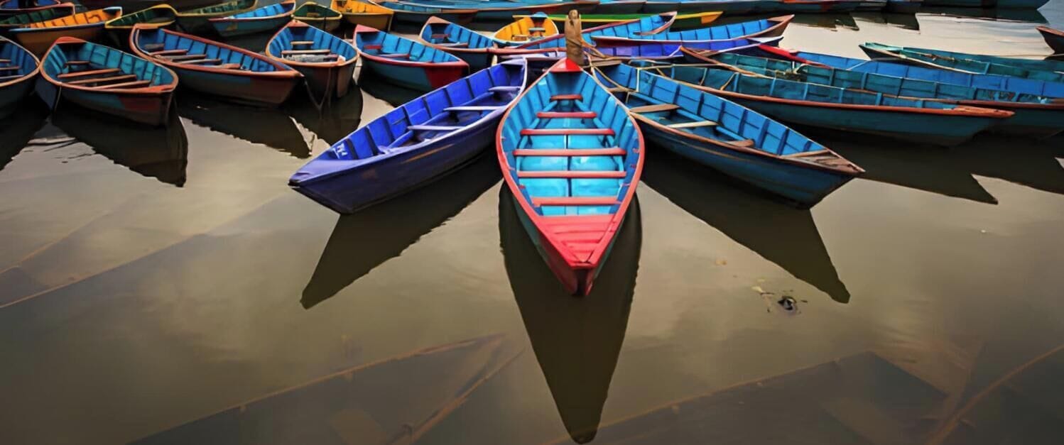 Una hilera de pequeñas embarcaciones alineadas sobre aguas tranquilas.