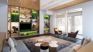 A modern living room with a sofa, coffee table, and chairs. There is a TV on a shelf and a fireplace. - Element Chongli (Zhangjiakou)