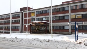 Um hotel com fachada de tijolos, várias janelas e uma placa com a inscrição 'Ravintola Savonian Hotel'.