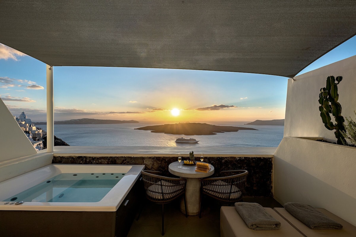 Un balcón con vistas al mar, un jacuzzi, un lavamanos y una planta de cactus.
